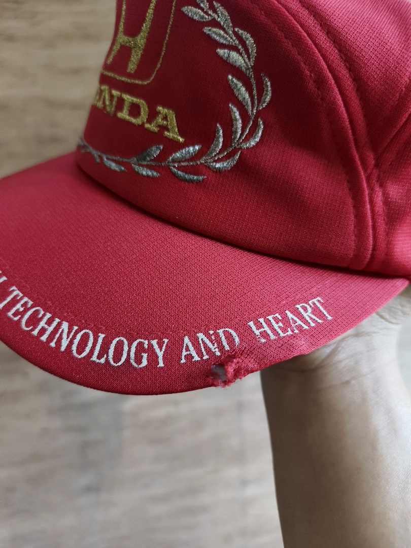 80's Honda Racing cap (Category: Caps & Hats) located in Davao. Submitted by vndrgd (Listing ID 1460187679, Image 2). Description: - Red Honda cap - Features Honda logo with laurel wreath design - Brim text: "THE PROUD PROFESSIONAL HAS BOTH TECHNOLOGY AND HEART" - Ideal for Honda enthusiasts.