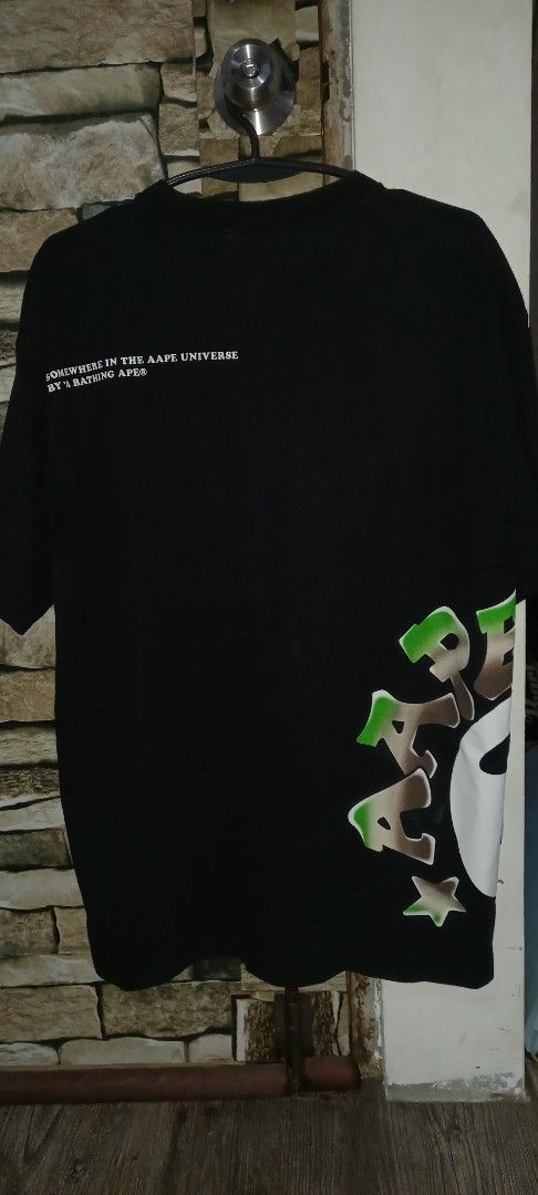 AAPE BY A BATHING APE (Category: Tshirts & Polo Shirts ) located in Cavite. Submitted by chard112345 (Listing ID 1460158269, Image 2). Description: - Brand: AAPE BY A BATHING APE - Color: Black - Size: L to Xl - Material: 100% Cotton - Front Design: AAPE logo and planet graphic - Back Design: Text reads 'SOMEWHERE IN THE AAPE UNIVERSE BY A BATHING APE'.