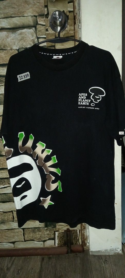 AAPE BY A BATHING APE (Category: Tshirts & Polo Shirts ) located in Cavite. Submitted by chard112345 (Listing ID 1460158269, Image 1). Description: - Brand: AAPE BY A BATHING APE - Color: Black - Size: L to Xl - Material: 100% Cotton - Front Design: AAPE logo and planet graphic - Back Design: Text reads 'SOMEWHERE IN THE AAPE UNIVERSE BY A BATHING APE'.