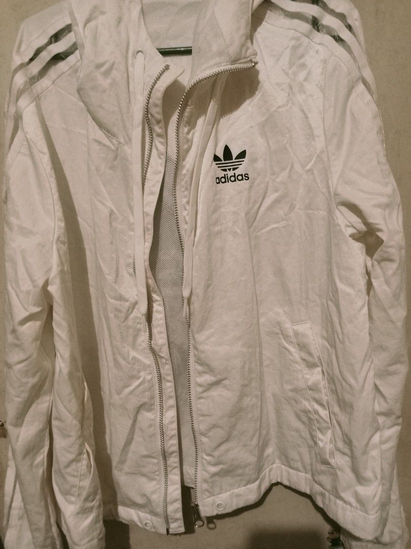 Adidas White Windbreaker Jacket with 3 Stripes (Category: Coats, Jackets and Outerwear) located in Manila. Submitted by shibafuwa (Listing ID 1460248281, Image 1). Description: - White Adidas windbreaker jacket - Classic 3 stripes on sleeves - Full zip front with hood - Breathable mesh lining - Ideal for casual wear or light workouts.