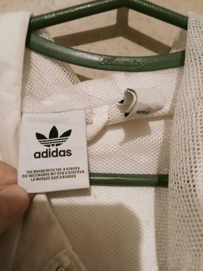 Adidas White Windbreaker Jacket with 3 Stripes (Category: Coats, Jackets and Outerwear) located in Manila. Submitted by shibafuwa (Listing ID 1460248281, Image 3). Description: - White Adidas windbreaker jacket - Classic 3 stripes on sleeves - Full zip front with hood - Breathable mesh lining - Ideal for casual wear or light workouts.