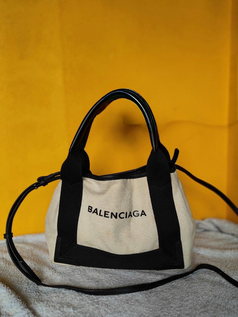 Balenciaga Canvas and Leather Mini Bag (Category: Luxury Bags & Wallets) located in Cebu City. Submitted by cherreymie70208 (Listing ID 1460266327, Image 1). Description: - 💯✅ Balenciaga Cabas XS Tote bag -Cut/missing pouch - Color: Beige canvas with black leather trim - Features: Top handles and detachable shoulder strap - Closure: Drawstring - Interior: Balenciaga branding - Size: Small and compact, ideal for essentials.
