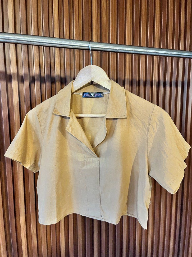 Beso Beso Collared Short Sleeve Cropped Top (Category: Blouses) located in Echague. Submitted by aeafitz (Listing ID 1460304776, Image 1). Description: - Brand: Beso Beso - Color: Light brown - Style: Cropped collared top - Sleeves: Short sleeves - Neckline: V-neck with pointed collar - Versatile: Great for casual wear or dressing up, pairs well with skirts and pants.