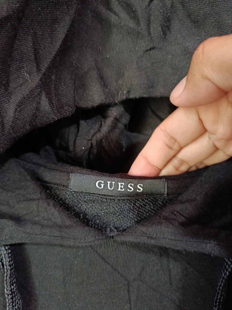 Black Guess Hoodie XL (Category: Hoodies) located in Kalamansig. Submitted by skone1996 (Listing ID 1460249134, Image 2). Description: - Guess Hoodie - Size: XL - 23 Width - 28 Length - 10/10 Color rate - No issue - Color: Black - Material: Cotton-Polyester Blend - Features: Front pocket, adjustable drawstrings - Design: Subtle embossed Guess logo on front - Ideal for: Casual wear.