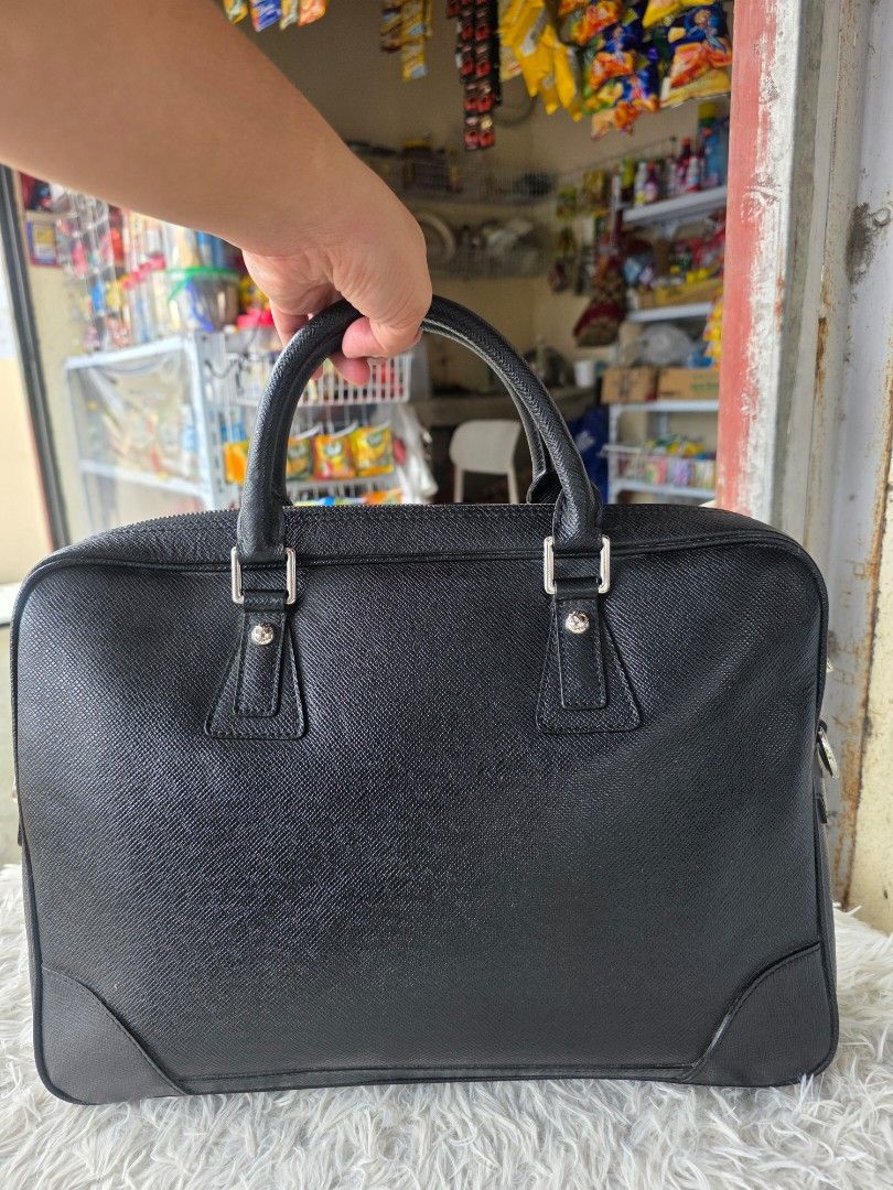 Prada Black Leather Briefcase (Category: Briefcases) located in Lemery. Submitted by venus23 (Listing ID 1460106317, Image 1). Description: - Genuine black leather briefcase - Textured finish for a sophisticated look - Comfortable top handles - Secure zip closure - Stylish silver hardware details - Generous interior space for essentials - Ideal for work, meetings, or travel - Approximately 15 inches wide.