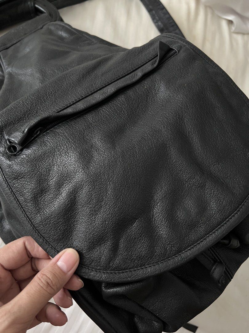 Black Leather Drawstring Backpack with Top Handle (Category: Backpacks) located in Pasig City. Submitted by jenscloset86 (Listing ID 1460167574, Image 3). Description: Brand: WILSON Material: Genuine Leather • see photos for some flaws. • some rust as seen in the photos. Measurement: Length: 9” Height: 16” Width: 9” - Genuine black leather backpack - Secure drawstring closure with button snap flap - Convenient front zip pocket - Sturdy top handle
