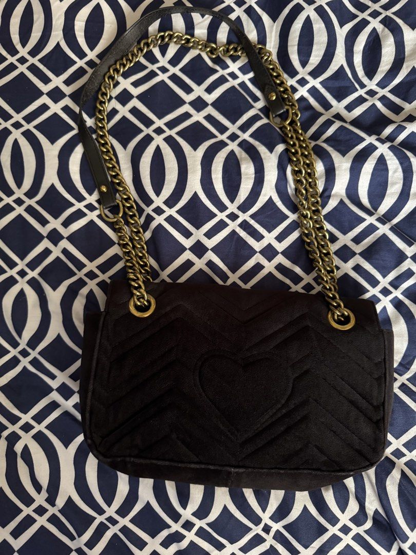 Black Velvet Shoulder Bag (Category: Shoulder Bags) located in Legazpi City. Submitted by grechaganda (Listing ID 1460163844, Image 2). Description: - black velvet shoulder bag - Features iconic GG logo hardware - Stylish quilted chevron pattern on the front - Adorable heart detail on the back - Elegant gold chain strap with comfortable leather shoulder pad - Ideal for nights out or elevating any outfit - Approximate dimensions: 9 inches wide x 6