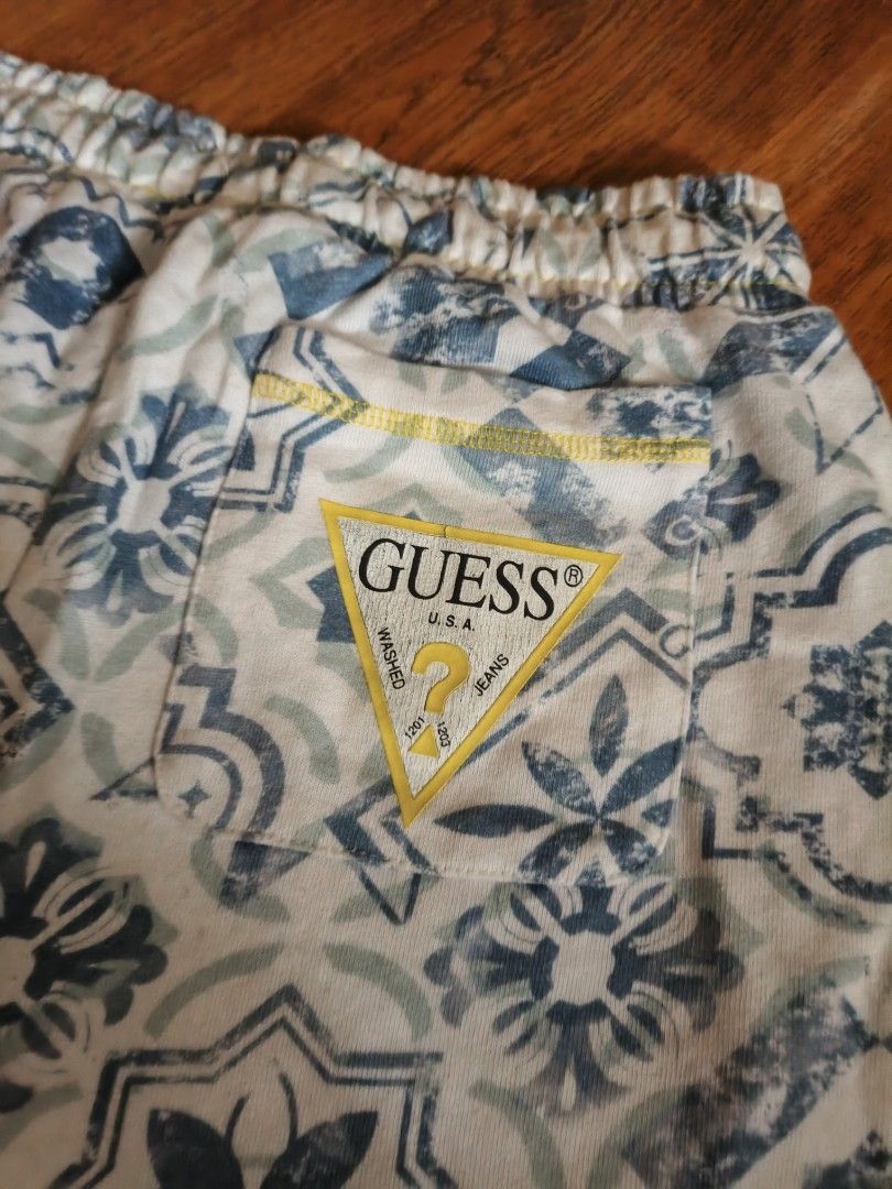 Bubdle Guess Shorts - Patterned & Striped Set (Category: Babies & Kids Fashion) located in Valenzuela. Submitted by emotika (Listing ID 1460295603, Image 1). Description: - Two pairs of shorts included. - Pair 1: Blue and white tile pattern with Guess logos. - Pair 2: White with grey stripes. - Both feature elastic waistbands and drawstrings for a comfortable fit. - Ideal for casual outings or relaxing at home. Fits upto 11 y o.