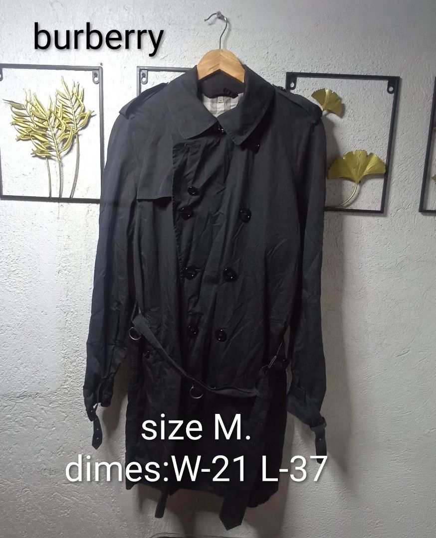 Burberry Double Breasted Trench Coat Size M (Category: Coats, Jackets and Outerwear) located in Kawit. Submitted by deidzdzn (Listing ID 1460205865, Image 1). Description: - Classic Burberry trench coat - Color: Dark Gray - Style: Double-breasted - Features: Belted waist with buckle - Size: M - Measurements: Width 21 inches, Length 37 inches - Interior: Iconic Burberry check lining - Perfect for layering.