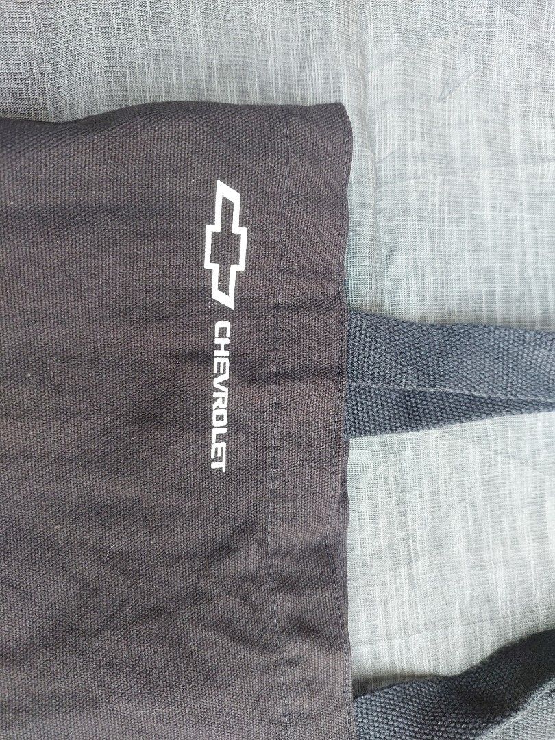 Chevrolet Tote Bag (Category: Tote Bags) located in Banga. Submitted by jahroldpan64406 (Listing ID 1460197837, Image 3). Description: - Black Chevrolet tote bag - Features Chevrolet logo and name on the front - Sturdy handles for comfortable carrying - Ideal for everyday use or casual shopping - A practical and stylish accessory for car enthusiasts.