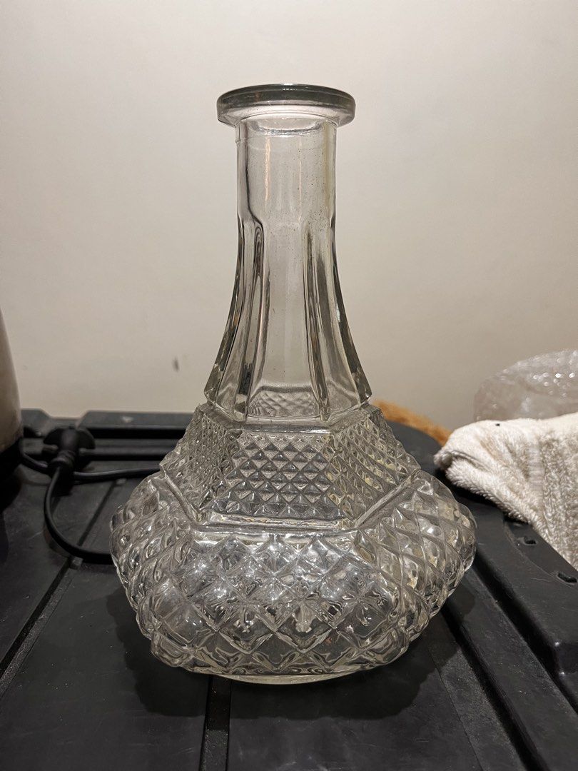 Clear Glass Decorative Vase (Category: Vases & Decorative Bowls) located in Caloocan City. Submitted by youngfalcon.54fe3e (Listing ID 1460176935, Image 1). Description: - Clear glass vase with decorative faceted base. - Smooth, tapering neck. - Unique geometric pattern on the lower half. - Ideal for displaying flowers or as a standalone decor piece. - Approx. [height] inches tall and [width] inches at widest point. - Clean and ready for use..