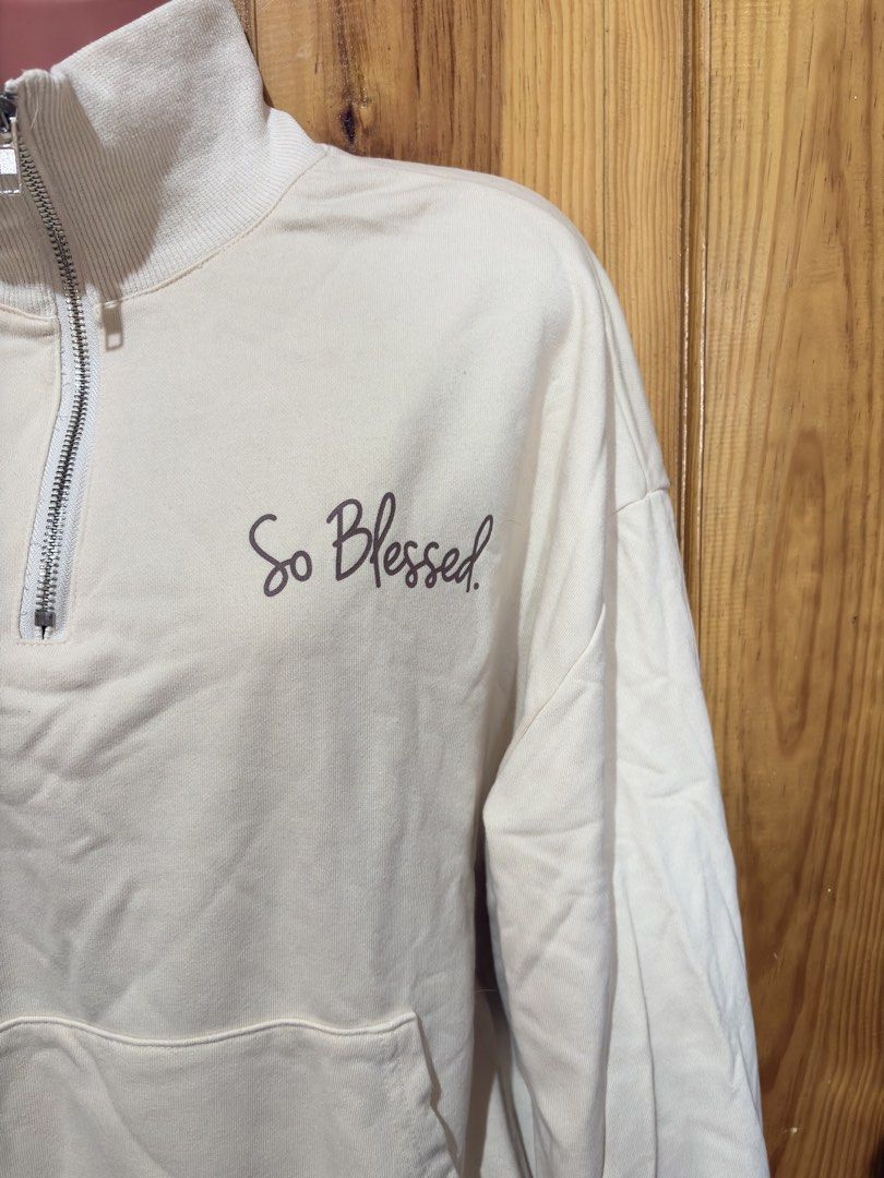Cream "So Blessed" Quarter Zip Sweatshirt (Category: Coats, Jackets and Outerwear) located in Baguio. Submitted by declutterbycys (Listing ID 1460169784, Image 2). Description: - Cream colored sweatshirt - "So Blessed" graphic on front and back - Quarter zip neckline - Front pouch pocket - Ribbed cuffs and hem - Super comfy and cozy feel - Ideal for casual wear.