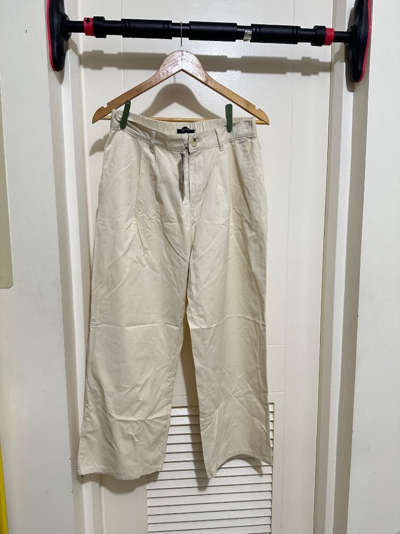 Cream Wide Leg Trousers (Category: Other Bottoms) located in Mandaluyong City. Submitted by lovedbyjaaaam (Listing ID 1460271987, Image 1). Description: - Cream colored wide leg trousers - High-waisted with a relaxed fit - Button and zip closure at the front - Two visible pockets - Versatile for casual wear or dressing up.