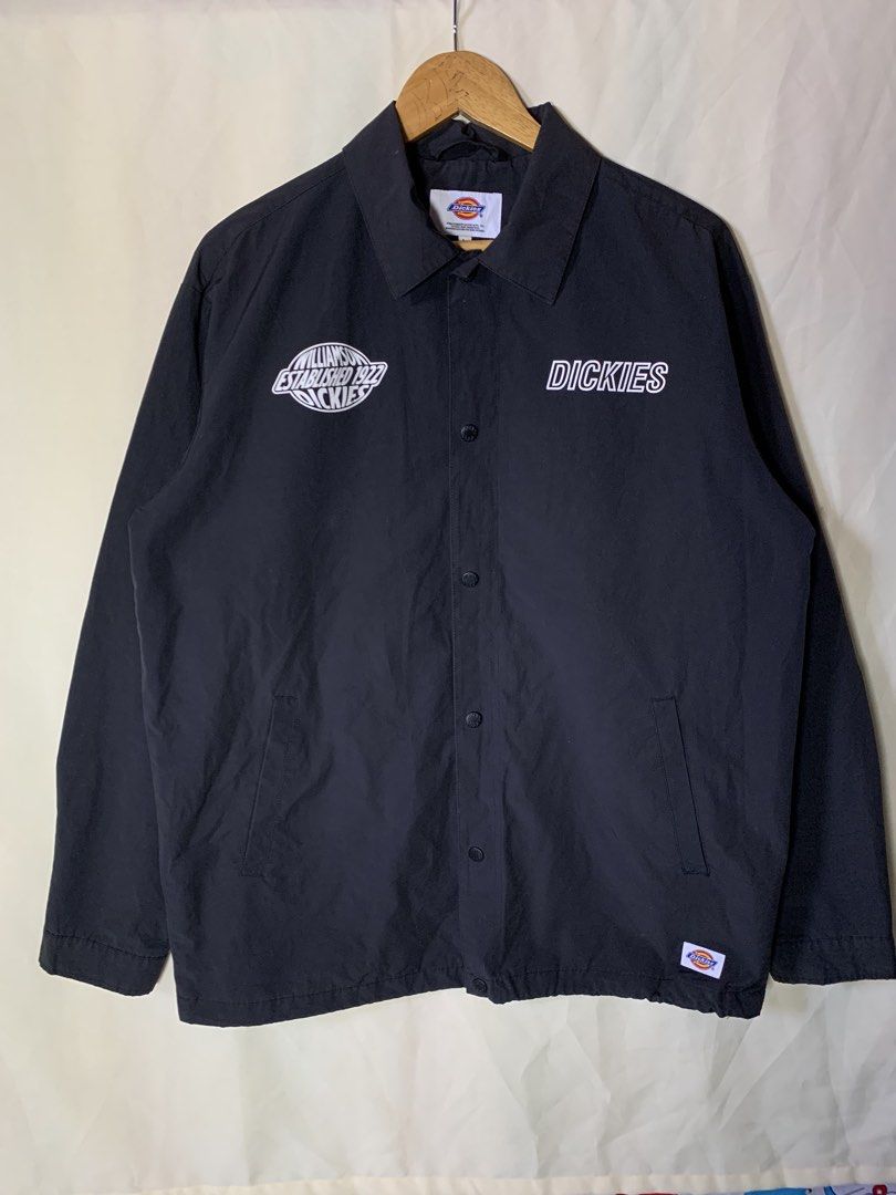 Dickies Black Coach Jacket "Established 1922" Logo Size L (Category: Coats, Jackets and Outerwear) located in Davao. Submitted by cheineebau09680 (Listing ID 1460209261, Image 1). Description: - Black Dickies Coach Jacket - Size: Large (L) - Features 'Williamson-Dickie' 1922 logo on left chest and 'Dickies' text on right - Button-up front with a classic collar - Material: Cotton and Polyester blend - Ideal for everyday casual wear.