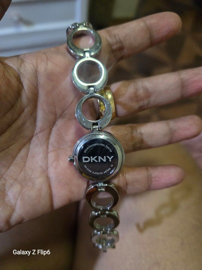 DKNY Silver Tone Bracelet Watch (Category: Women's Watches) located in Valenzuela. Submitted by calmstone_faded (Listing ID 1460189922, Image 2). Description: - DKNY watch - Silver tone metal bracelet with circular cutouts - Round watch face with silver hands - Stylish accessory for everyday wear or dressing up.