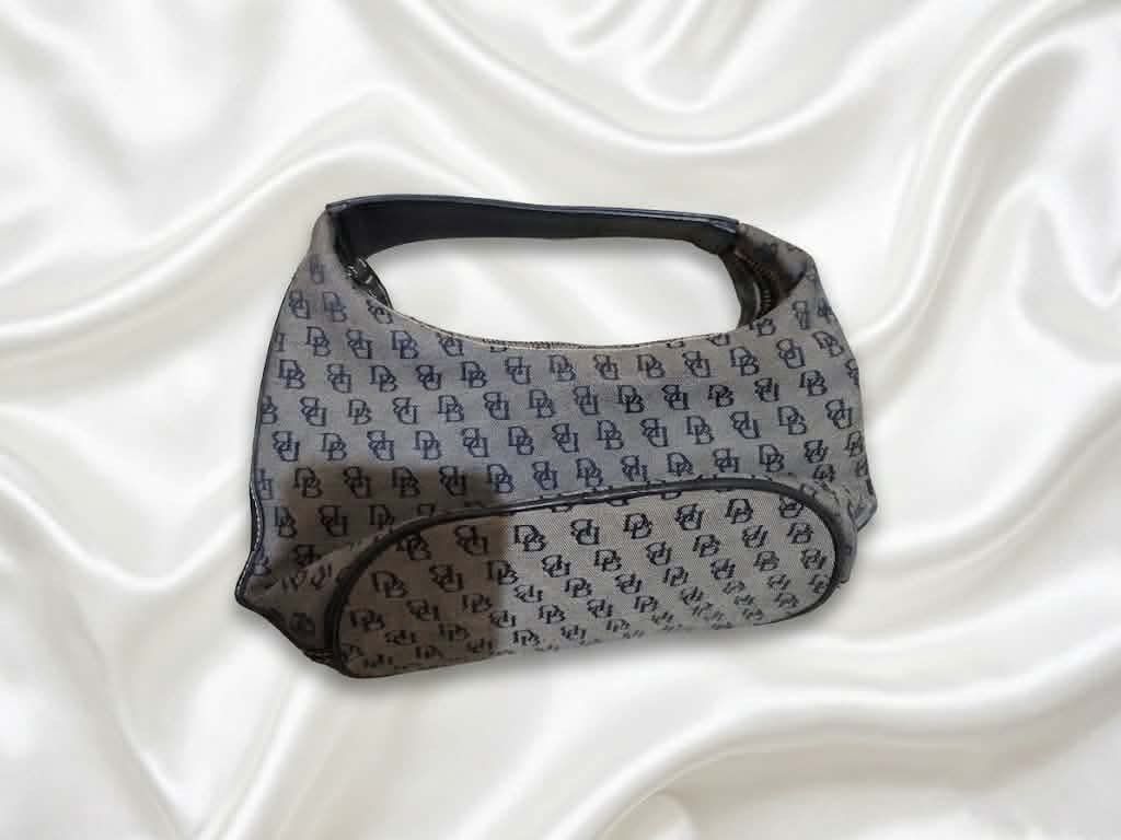 Dooney & Bourke Monogram Shoulder Bag (Category: Luxury Bags & Wallets) located in Calamba. Submitted by vtg_ukay_bags (Listing ID 1460198944, Image 1). Description: - Classic Dooney & Bourke shoulder bag - Features all-over DB monogram pattern - Color: Dark grey canvas with black leather trim - Closure: Zipper - Ideal for everyday use.