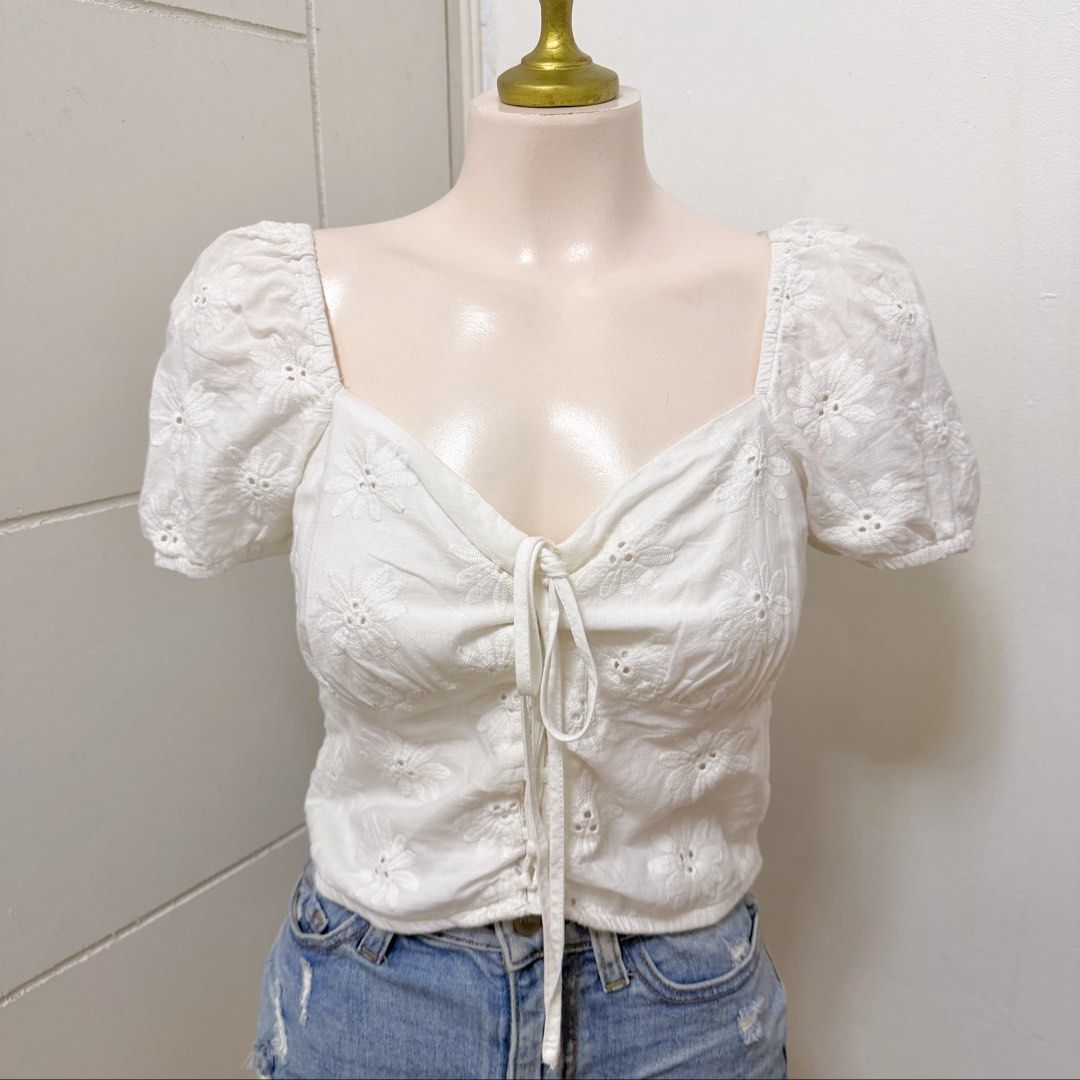 FB SISTER White Tie-Front Eyelet Top [S] (Category: Blouses) located in Malabon City. Submitted by k_intimates (Listing ID 1460293786, Image 1). Description: Details: • Size Small • No issues (no stains, but need to wash since nastore sa clothing rack) • White, short-sleeve crop top with a sweetheart neckline, and a drawstring front tie detail featuring delicate floral eyelet embroidery..