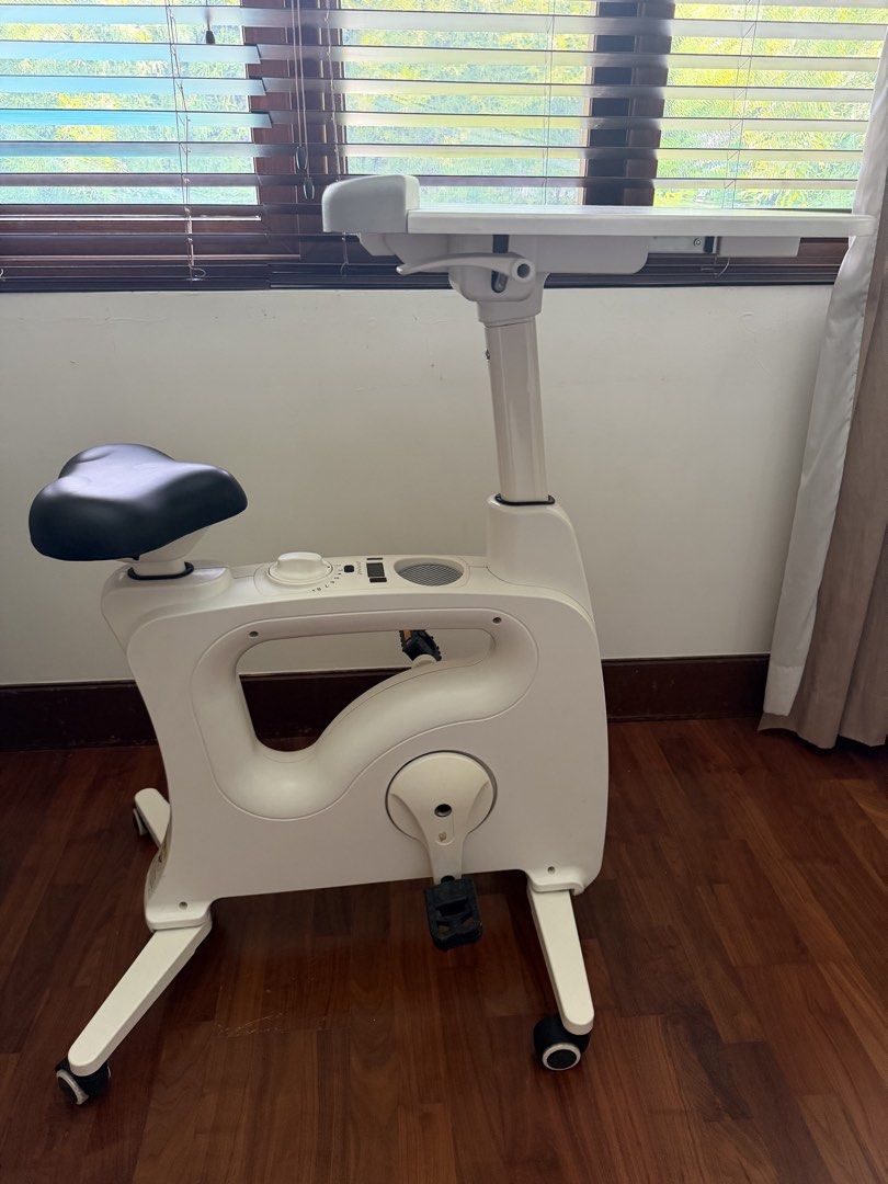 FlexiSpot White Exercise Bike Desk (Category: Cardio & Fitness Machines) located in Muntinlupa City. Submitted by lighterclosets (Listing ID 1460166741, Image 1). Description: - White exercise bike with built-in desk - Stay productive while you exercise - Adjustable desk height - Multiple resistance levels (dial indicator) - Wheels for easy portability - Compact design, ideal for home use.