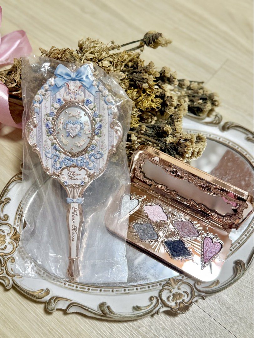 Flower Knows Mirror and Eyeshadow Palette Set (Category: Makeup) located in Manila. Submitted by truephoenix.fd5a21 (Listing ID 1460263826, Image 1). Description: - Adorable hand mirror with a charming blue ribbon and bunny design. - Brand new, still in its original packaging. - Includes a beautiful rose gold eyeshadow palette. - Palette features a mix of shimmery and matte shades. - Some eyeshadow pans are uniquely shaped like hearts. - Ideal fo