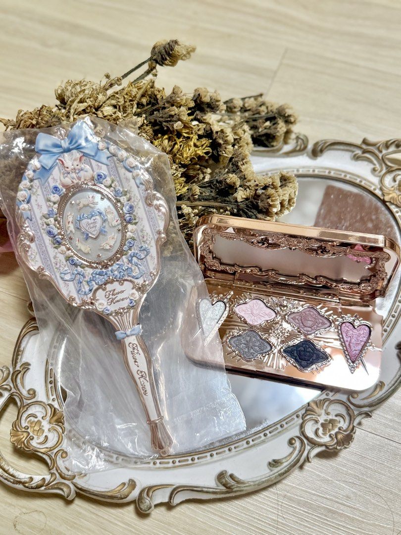 Flower Knows Mirror and Eyeshadow Palette Set (Category: Makeup) located in Manila. Submitted by truephoenix.fd5a21 (Listing ID 1460263826, Image 2). Description: - Adorable hand mirror with a charming blue ribbon and bunny design. - Brand new, still in its original packaging. - Includes a beautiful rose gold eyeshadow palette. - Palette features a mix of shimmery and matte shades. - Some eyeshadow pans are uniquely shaped like hearts. - Ideal fo