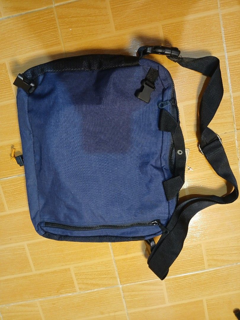 Garfield Juniors Navy Blue Messenger Bag (Category: Sling Bags) located in Manila. Submitted by asianwave189184 (Listing ID 1460247201, Image 3). Description: - Navy blue messenger bag from Garfield Juniors - Adjustable strap with buckle closure - Unique bungee cord detail on the front - Multiple pockets and compartments for organization - Ideal for school or everyday carry - Approximately 14 inches wide.