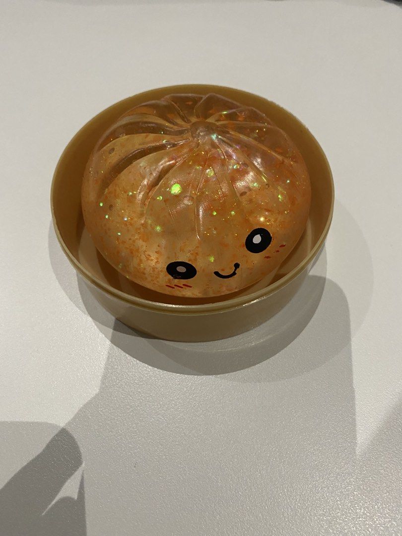 Glitter Dumpling Squishy (Category: Designer & Blind Box Toys) located in Dasmarinas. Submitted by closetcleanser_ (Listing ID 1460215443, Image 2). Description: Glitter Squishy Dumpling in color orange very satisfying and I didn’t play with it a lot so it’s as good as new .