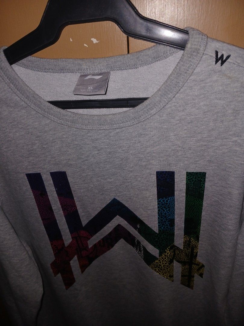 Gray crewneck sweatshirt (Category: Coats, Jackets and Outerwear) located in Quezon City. Submitted by dealmaker8 (Listing ID 1460183343, Image 3). Description: gray crewneck sweatshirt featuring a vibrant, multi-colored patterned Alan Walker logo on the front width 22 length 27.