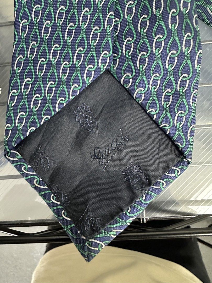 Gucci Silk Tie Made in Italy (Category: Ties) located in Manila. Submitted by declutterpromax (Listing ID 1460195382, Image 2). Description: - Authentic Gucci tie - Color: Navy blue with green and white chain link pattern - Material: 100% Silk - Origin: Made in Italy - Perfect for formal occasions or adding luxury to any outfit - Please check photos for detailed condition.