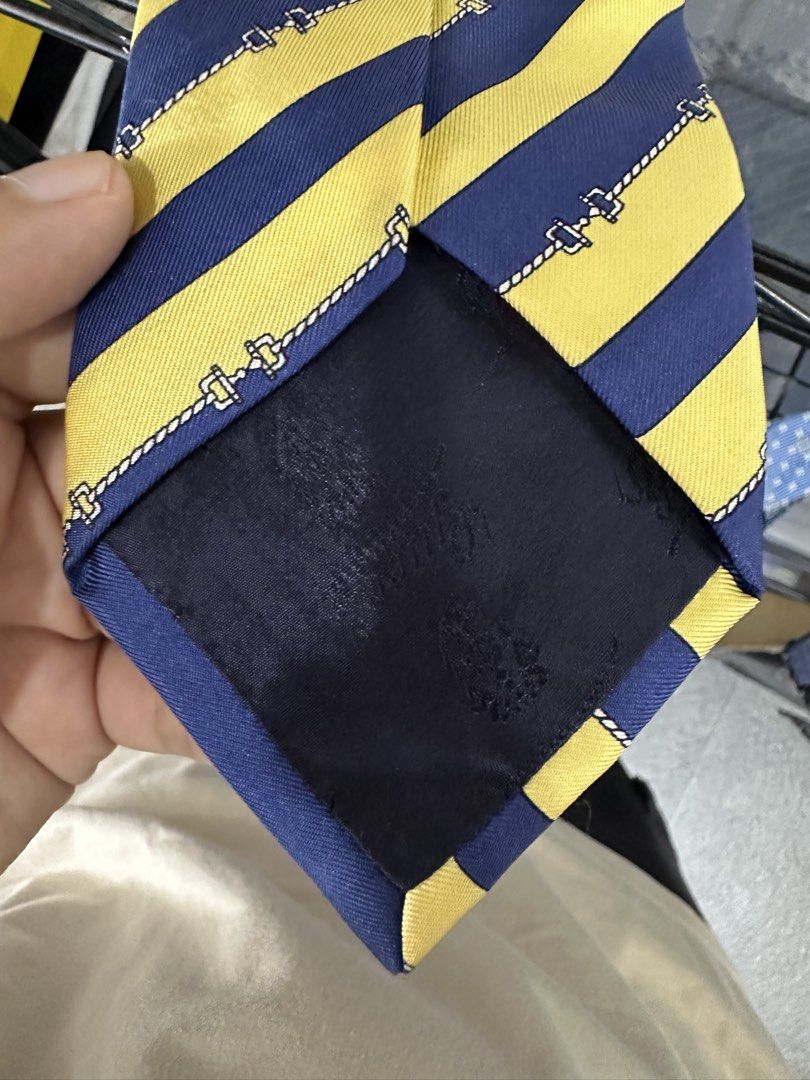 Gucci Silk Tie Made in Italy (Category: Ties) located in Manila. Submitted by declutterpromax (Listing ID 1460197559, Image 2). Description: - vintage Gucci tie - 100% Silk - Classic Gucci logo and emblem - Navy blue and yellow striped pattern - Made in Italy - Perfect accessory to elevate any outfit.