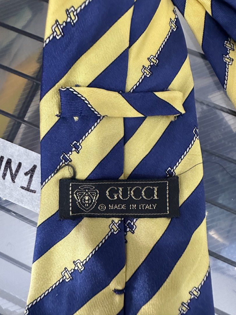 Gucci Silk Tie Made in Italy (Category: Ties) located in Manila. Submitted by declutterpromax (Listing ID 1460197559, Image 3). Description: - vintage Gucci tie - 100% Silk - Classic Gucci logo and emblem - Navy blue and yellow striped pattern - Made in Italy - Perfect accessory to elevate any outfit.