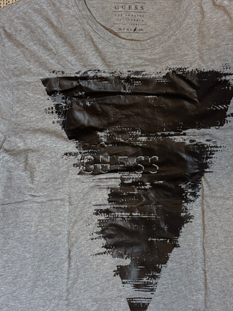 Guess Los Angeles Graphic Tee Grey (Category: Tshirts & Polo Shirts ) located in Manila. Submitted by juddscloset (Listing ID 1460249791, Image 2). Description: Guess Los Angeles graphic t-shirt, grey, distressed-print black triangle/text design on front. Preloved, from my own closet. Measured: Chest 50cm flat (~19.7” / ~39.4” circumference) | Length 68cm (~26.8”) | Sleeve opening 17cm flat (~6.7”).