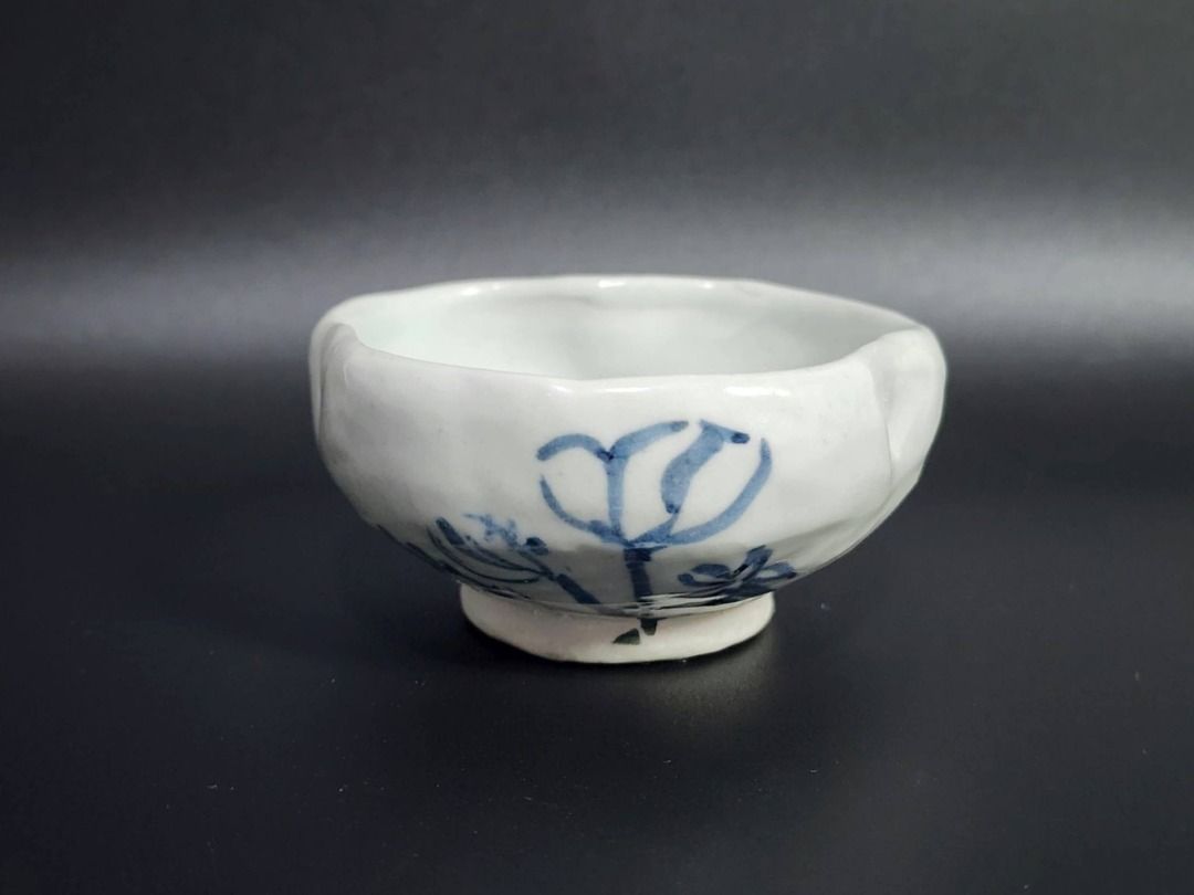 Hand-Painted Blue & White Ceramic Tea Bowl (Category: Vases & Decorative Bowls) located in Quezon City. Submitted by lacasetta (Listing ID 1460245776, Image 1). Description: Charming hand-painted East Asian ceramic tea bowl / small cup featuring an irregular scalloped rim and a simple blue underglaze floral motif. The restrained blue-and-white palette, organic form, and expressive brushwork evoke the character of traditional East Asian folk ceram