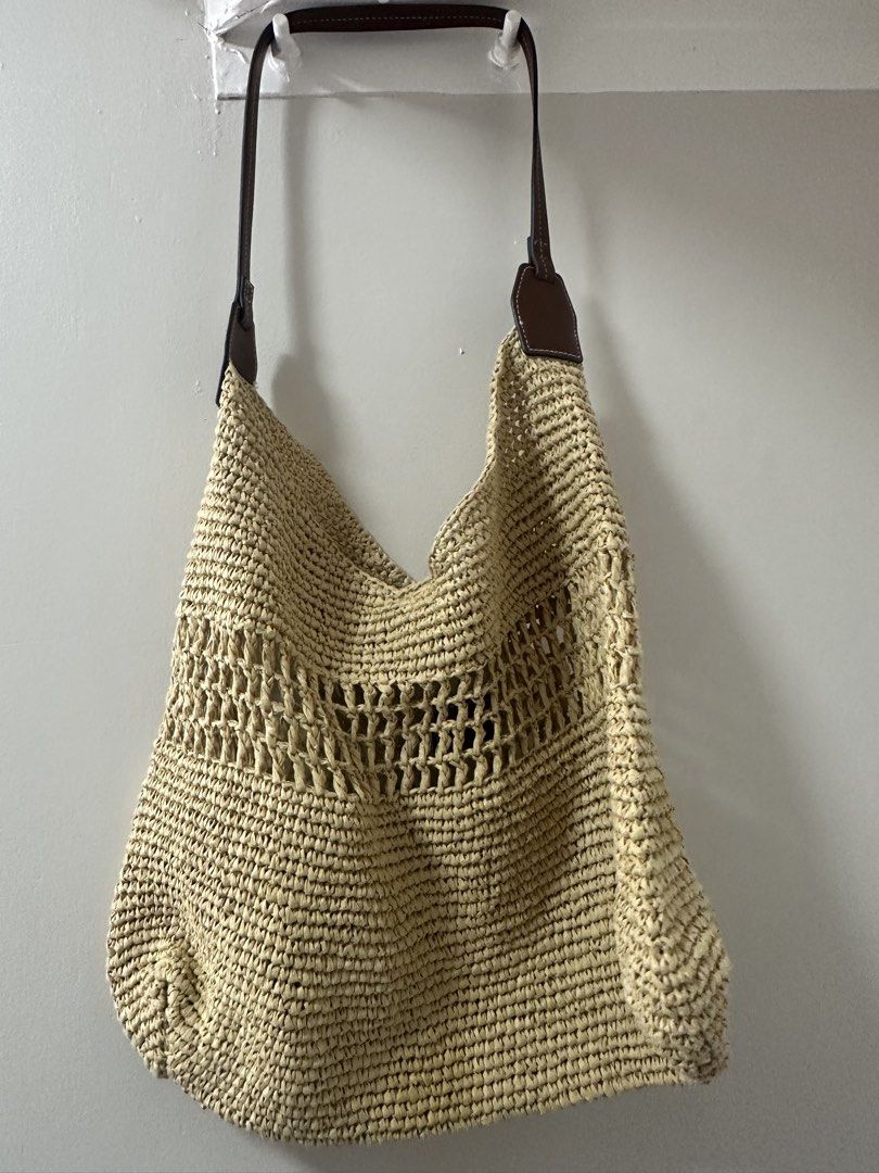 H&M Beige Straw Shoulder Bag (Category: Beach Bags) located in San Fernando. Submitted by vhiamaree6 (Listing ID 1460275428, Image 1). Description: Style: Hobo-style slouchy shoulder bag featuring an intricate open-weave middle panel. Material: 100% braided paper straw shell with a 100% polyurethane (coated fabric) dark brown strap. Interior: Unlined single-compartment design. Vibe: Relaxed summer aesthetic, often styled for beach vacations or ca