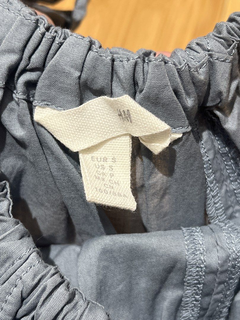 H&M Grey Blue Blouse Tie Shoulder Top (Category: Sleeveless) located in Quezon City. Submitted by randomstuffbychloeb (Listing ID 1460163813, Image 2). Description: - H&M GreyBlue Top - Tie Shoulder Straps - Elasticated Neckline - Flowy A-line Cut - Estimated Size: S - Versatile for casual or dressed-up looks.
