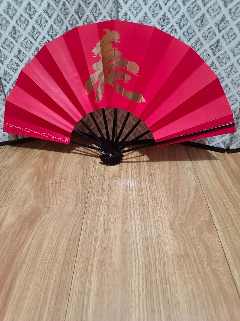 Japanese Traditional Paper Fan (Category: Fans) located in Makati City. Submitted by nyxhemera26 (Listing ID 1460168748, Image 1). Description: Japanese Traditional Paper Fan - Elegant red folding fan - Features a gold Chinese character symbolizing 'spring' - Sturdy black handle - Compact and portable when folded - Ideal for home decor or personal cooling - A festive addition for Chinese New Year celebrations.