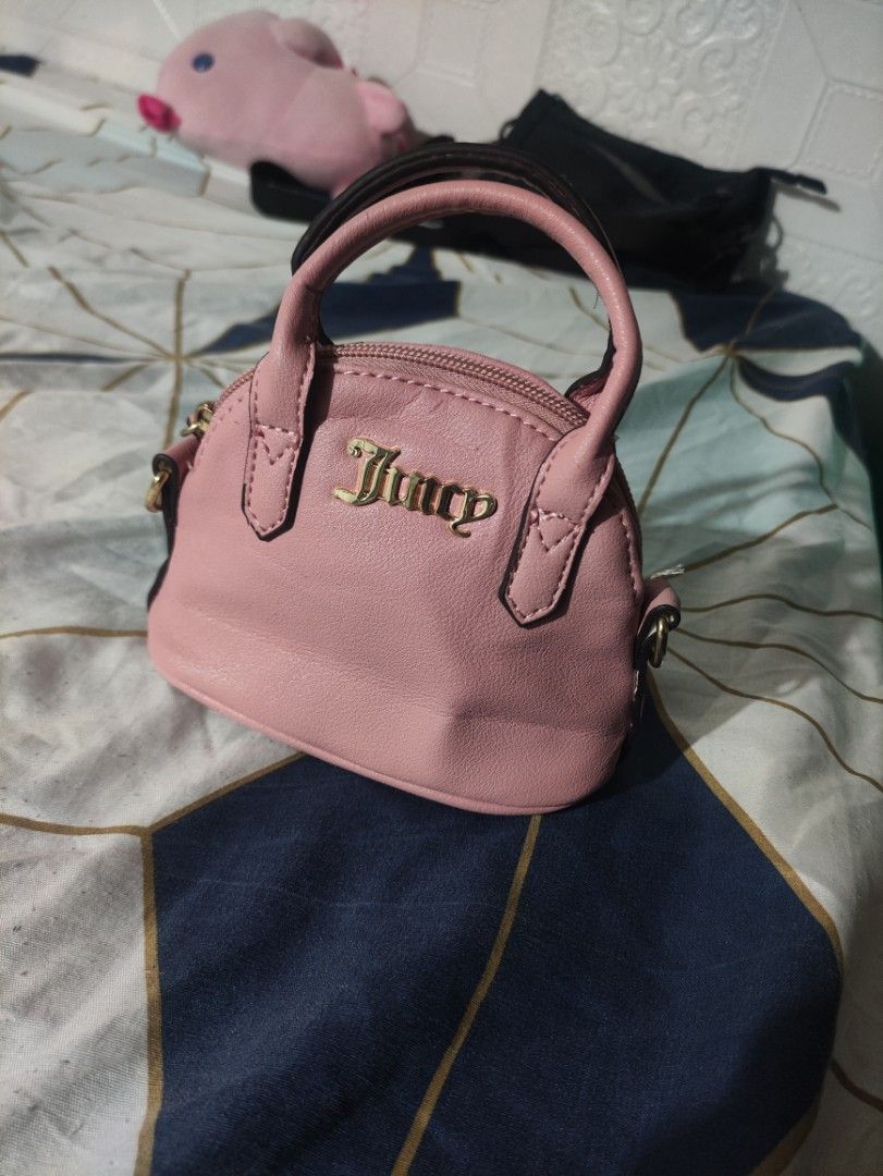 Juicy Couture Pink Mini Handbag with Strap (Category: Luxury Bags & Wallets) located in Rizal. Submitted by itsyoboiadji (Listing ID 1460268310, Image 1). Description: - Cute pink mini handbag - Brand: Juicy Couture - Features a top handle - Includes a detachable crossbody strap - Interior lining with all-over Juicy Couture logo - Made in Cambodia - Ideal for carrying your essentials - As new condition .
