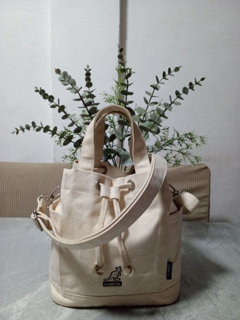 Kangol Canvas Bucket Bag Cream (Category: Cross-body Bags) located in Manila. Submitted by cosmiccloud-9236 (Listing ID 1460207873, Image 1). Description: - Cream colored canvas bucket bag from Kangol - Features a drawstring closure - Includes a detachable shoulder strap - Also has top handles for versatile carrying - Two convenient side pockets - Simple and classic design, ideal for everyday use.