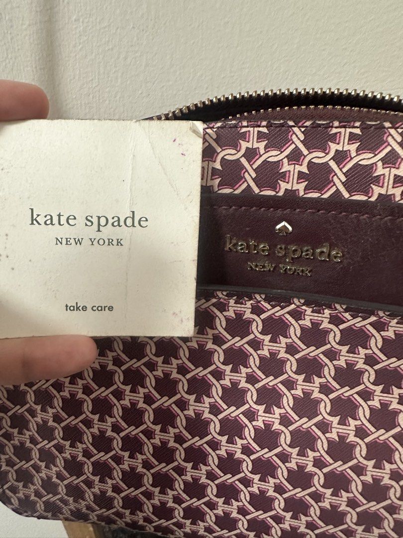 Kate Spade Spade Link Camera Bag in Burgundy/Deep Cherry (Category: Cross-body Bags) located in San Fernando. Submitted by vhiamaree6 (Listing ID 1460176581, Image 2). Description: Product Details Material: Crafted from durable Saffiano PVC (coated canvas) with smooth leather/Saffiano trim. Design: Features an all-over signature "Spade Link" geometric print, a top zip closure, and a metal pinmount brand logo on the front leather panel. Pockets: E
