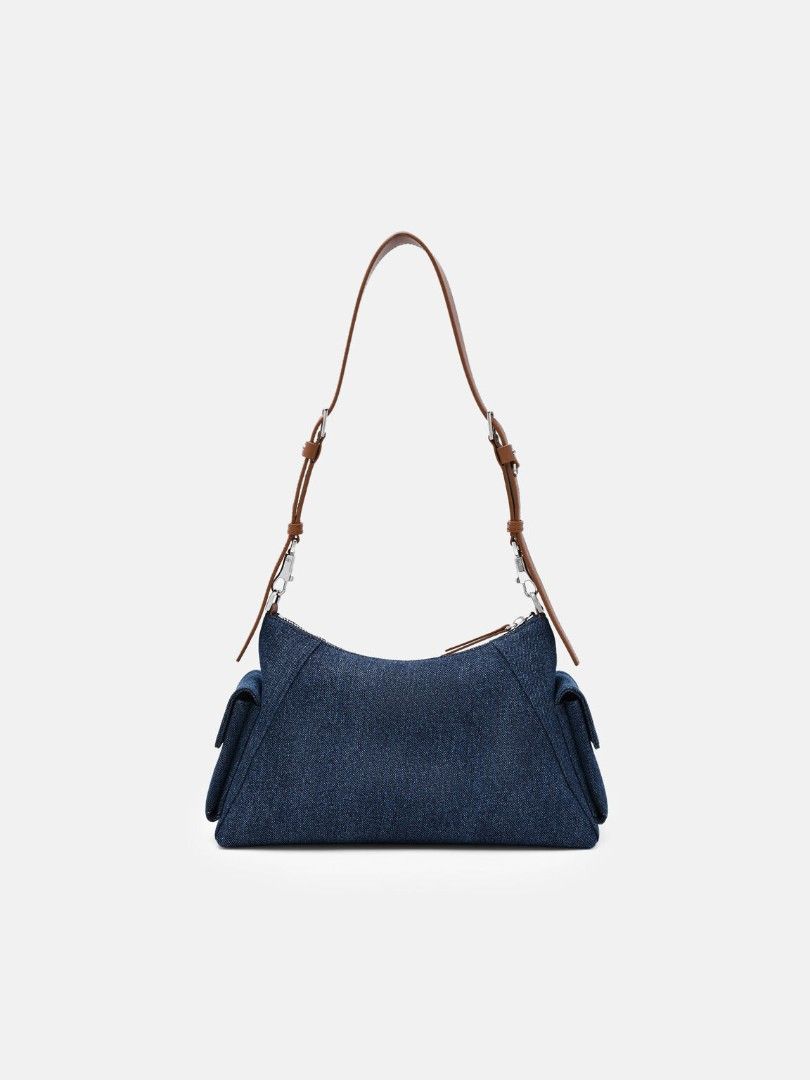 Kristen Denim Shoulder Bag - Blue Denim (Category: Announcements) located in Makati City. Submitted by zoeppe_online (Listing ID 1460298764, Image 3). Description: Defined by a utilitarian-inspired aesthetic, this slouchy shoulder bag is punctuated by functional zip details and structured side pockets. It features a wide, adjustable strap with polished hardware for a customizable fit. A contemporary take on the carry-all, balancing tactile softne