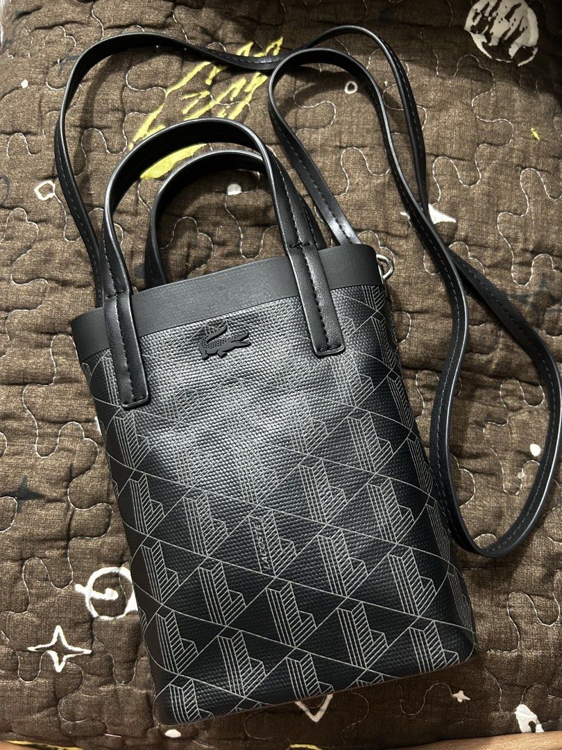 Lacoste Black Monogram sling bag (Category: Tote Bags) located in Manila. Submitted by everything.at.rhums (Listing ID 1460108232, Image 1). Description: - Authentic Black Lacoste Tote Bag - All-over signature monogram pattern - Dual top handles - crossbody strap for versatile wear - Secure interior snap closure - Compact 'small' size, ideal for carrying your daily essentials - Interior is clean and well-maintained -9.5 condition.
