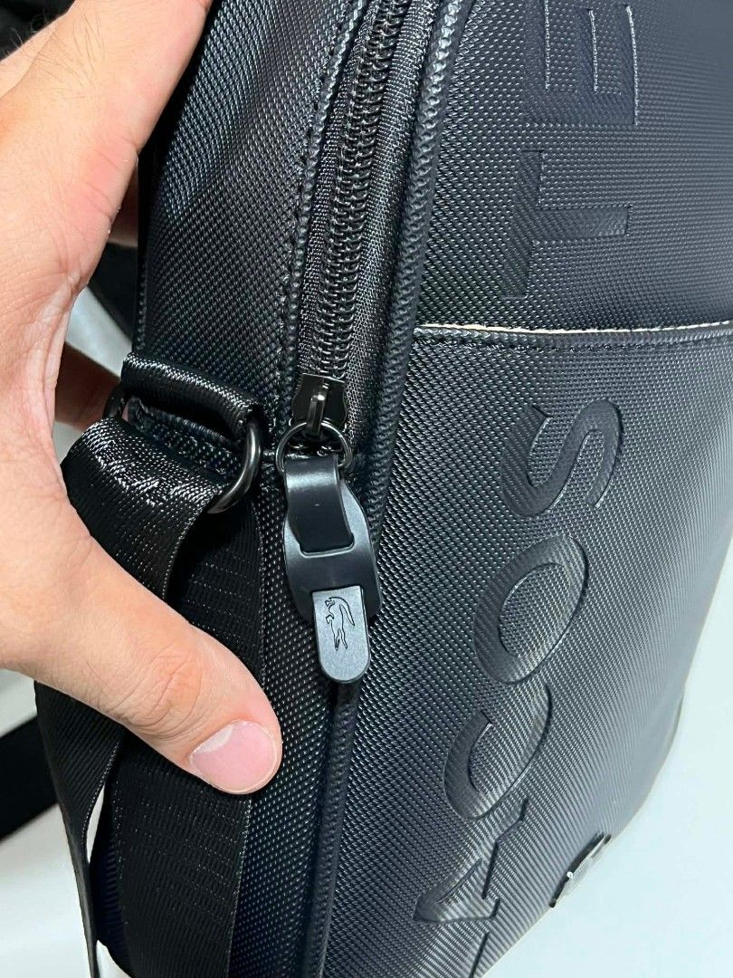 Lacoste Black Textured Crossbody Bag (Category: Sling Bags) located in Manila. Submitted by sonchan2point4 (Listing ID 1460109743, Image 2). Description: 2024 bought no issues, still good condition - Authentic Black Lacoste Crossbody Bag - Textured material with embossed "LACOSTE" lettering - Iconic crocodile logo detail - Secure zipper closure - Adjustable strap for comfortable wear - Ideal for everyday use and carrying essentials.