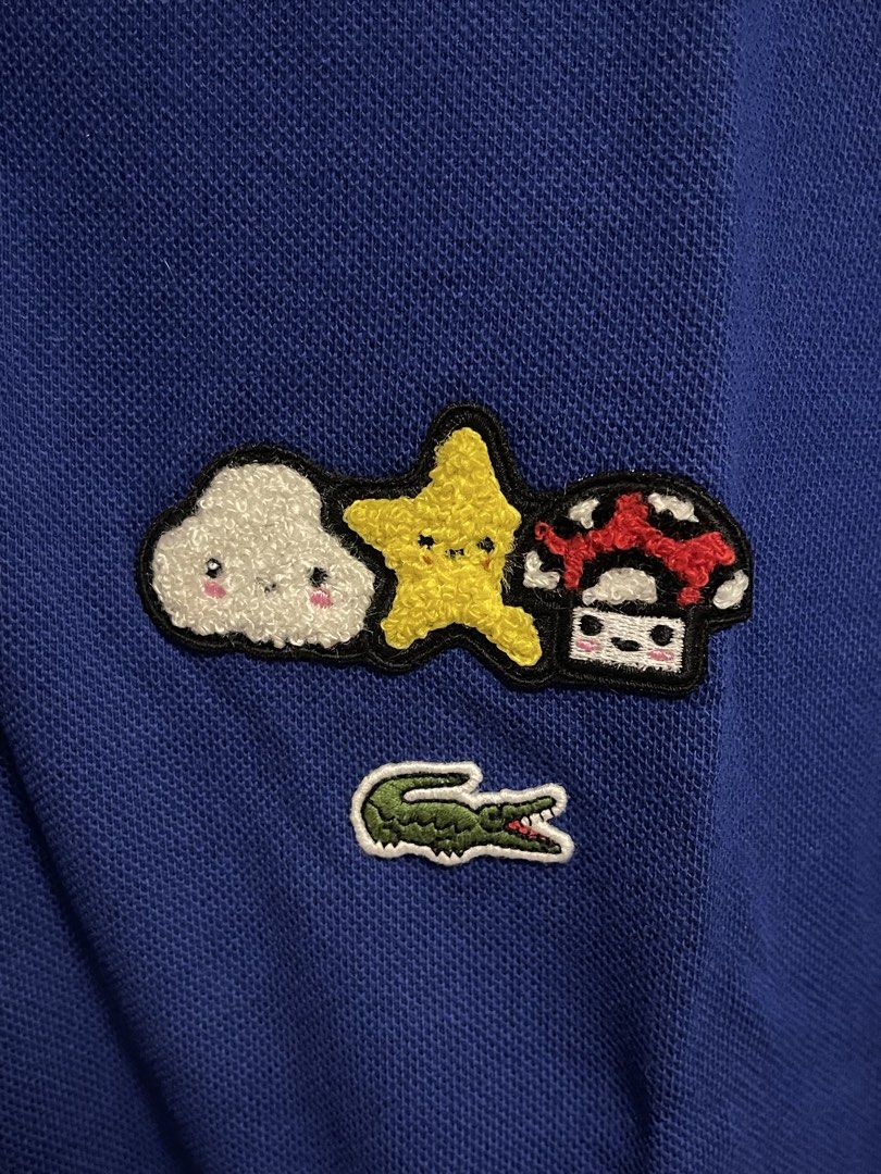 Lacoste Poloshirt (Category: Tshirts & Polo Shirts ) located in Manila. Submitted by alldayshoppinggirl (Listing ID 1460187630, Image 2). Description: 💯% ORIGINAL Negotiable Blue Lacoste x FriendsWithYou classic fit polo shirt featuring playful, embroidered cartoon character patches on the chest. standard Lacoste Medium (Size 4) in a Classic Fit has the following approximate flat-lay dimensions: Chest / Pit to Pit Width: 21 inches (approx. 54 cm