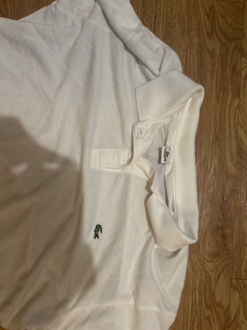Lacoste White Polo Shirt (Category: Tshirts & Polo Shirts ) located in Manila. Submitted by silentowl_7cf53c (Listing ID 1460246431, Image 3). Description: - Classic white Lacoste polo shirt - Features iconic green crocodile logo - Short sleeves - Collared neckline - Versatile for casual or smart-casual outfits.