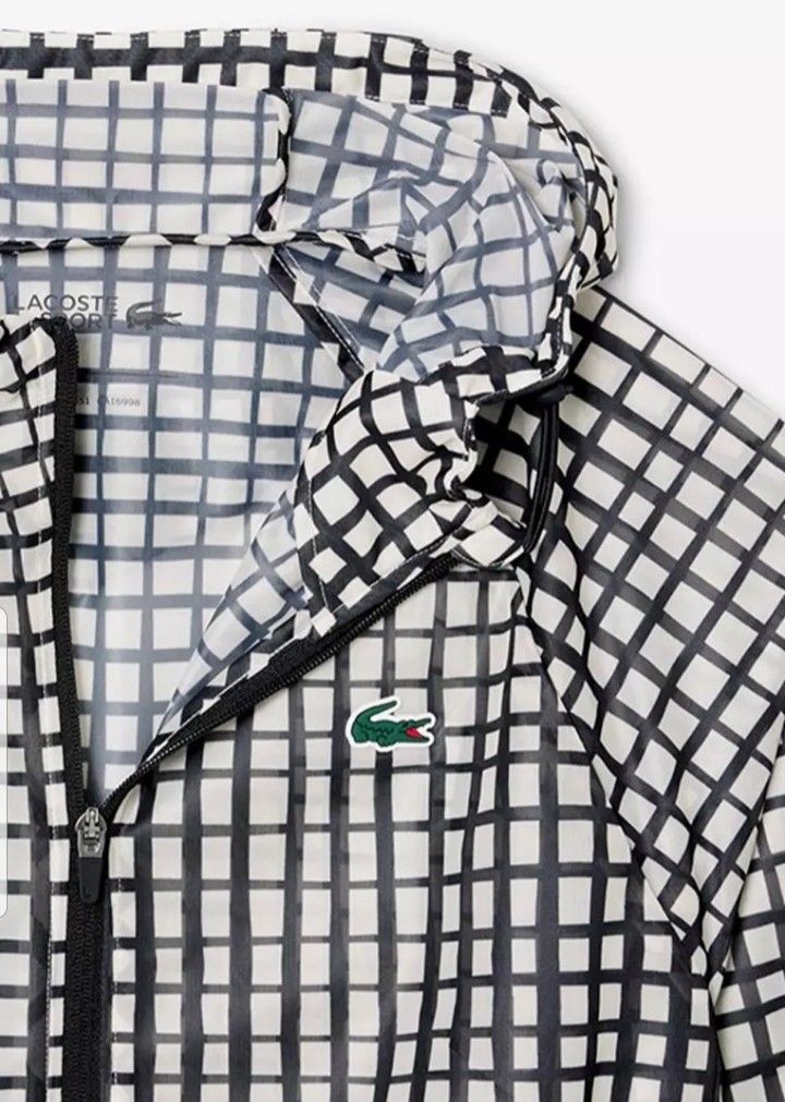 Lacoste Windbreaker Jacket (Category: Coats, Jackets and Outerwear) located in San Mateo. Submitted by wellhomes (Listing ID 1460121435, Image 1). Description: - Cool grid pattern windbreaker from Lacoste - Lightweight material, perfect for layering - Features the iconic crocodile logo - Zip-up front with convenient pockets - Hooded design for added protection - Ideal for casual wear or light outdoor activities - AUTHENTIC .