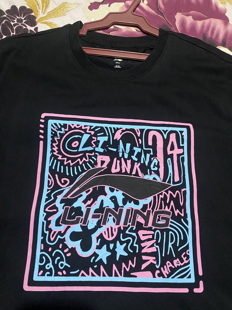 Li-Ning Dunk T-Shirt Black Graphic Tee (Category: Tshirts & Polo Shirts ) located in Manila. Submitted by thrift.ed_ph (Listing ID 1460162313, Image 2). Description: - Black Li-Ning t-shirt - Features 'Li-Ning Dunk' and 'Charles' graphic print - Graphic has pink and blue outlines - Ideal for casual wear.