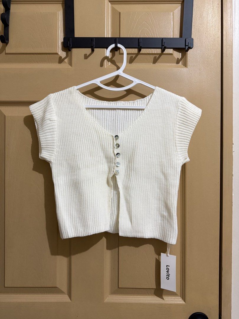 Lovito White Knit Button-Up Cropped Cardigan (Category: Coats, Jackets and Outerwear) located in Manila. Submitted by chavirly (Listing ID 1460190668, Image 1). Description: - Brand: Lovito - Style: White knit cropped cardigan - Features: Short sleeves, V-neckline - Closure: Four buttons down the front - Condition: Brand new with original tag attached - Versatility: Great for layering or wearing on its own - Feel: Super comfy and stylish.