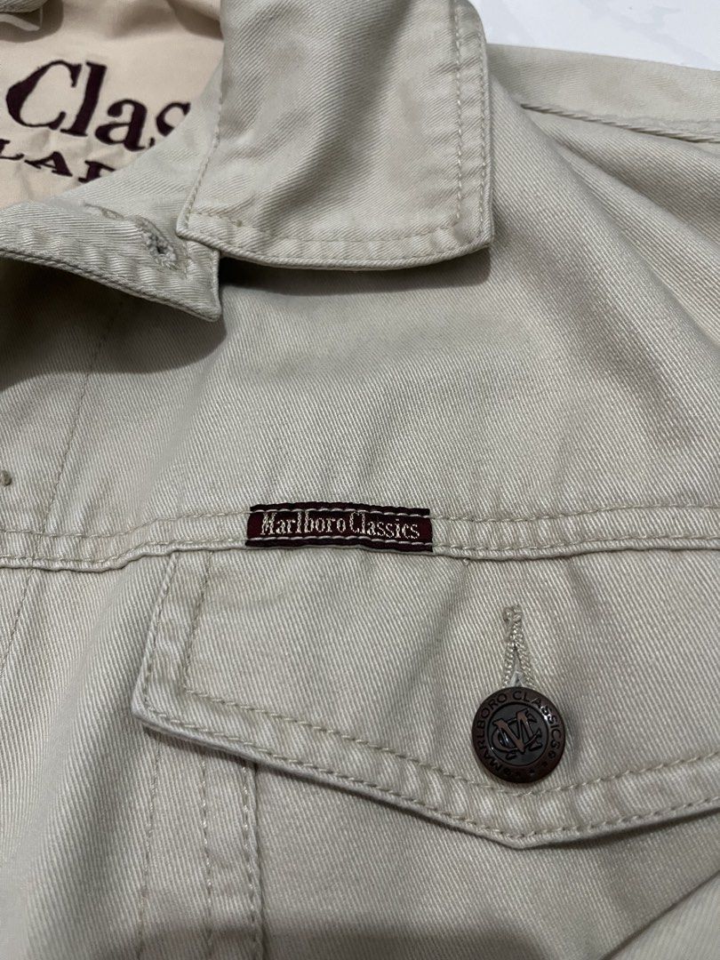 Marlboro Classics Beige Denim Jacket Size Small (Category: Coats, Jackets and Outerwear) located in Urdaneta. Submitted by supremo_fi (Listing ID 1460119782, Image 2). Description: - Issue: wash - Classic Marlboro Classics jacket - Beige color, denim-like material - Marlboro Classics logo on chest pocket - Leather patch on the side - Tag indicates size Small - Ideal for casual wear.