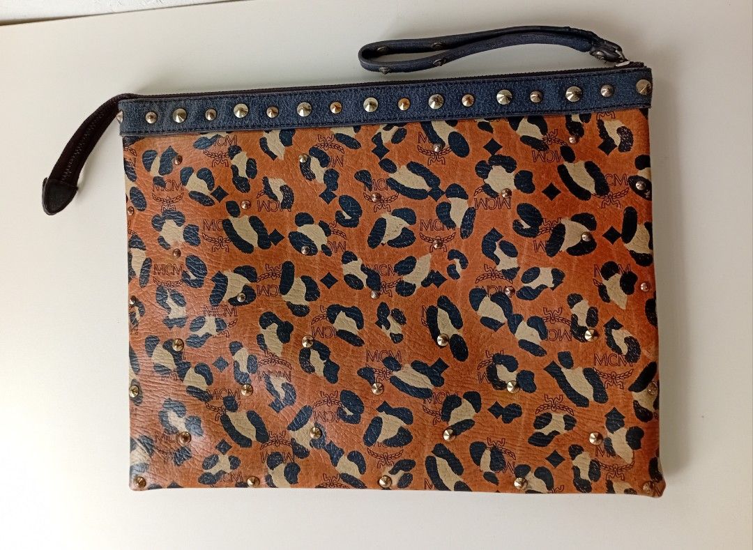 MCM Leopard Print Studded Clutch Bag (Category: Luxury Bags & Wallets) located in Navotas City. Submitted by riyuwi (Listing ID 1460163448, Image 3). Description: PreOwned lightly Used Authentic MCM leopard Printed Studded leather clutch bag Large - Classic MCM monogram with leopard print overlay - Edgy studded details along the top edge - Interior zippered pocket - Ideal for carrying your essentials Sign of Used Good Condition 8.9/10 .