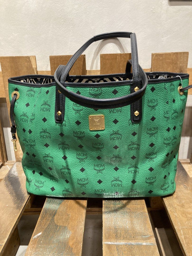 MCM Visetos Green Tote Bag (Category: Luxury Bags & Wallets) located in Quezon City. Submitted by janisu0303 (Listing ID 1460294475, Image 1). Description: - Authentic MCM tote bag - 10,500 php - Signature Visetos pattern all over - Black trim and handles - Gold-tone hardware - Spacious interior, ideal for everyday use - Interior lining with black and white pattern - Snap closure on sides This Reversible shopper tote from MCM has been fabulously 