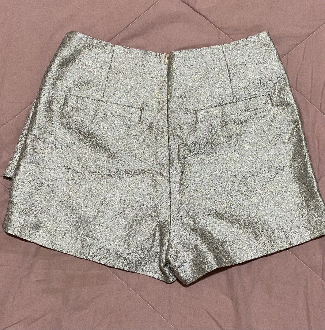 Metallic Pleated Skort Shorts (Category: Shorts) located in Bacolod City. Submitted by bravefire_3fe6dd (Listing ID 1460301364, Image 2). Description: - Metallic shorts with a pleated front, giving a skirt-like illusion. - Functional back pockets. - Decorative pockets on the front. - Convenient front zipper closure. - Fabric boasts a beautiful shimmer. - Ideal for evening wear or special occasions..
